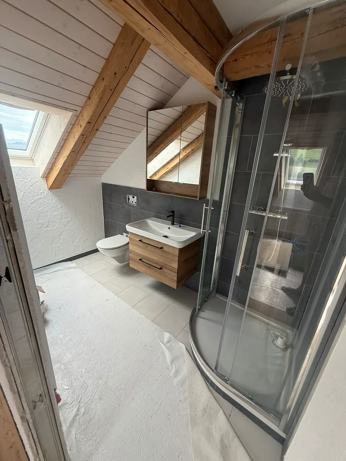 Neues Badezimmer im Dachgeschoss mit Duschkabine unter der Dachschräge